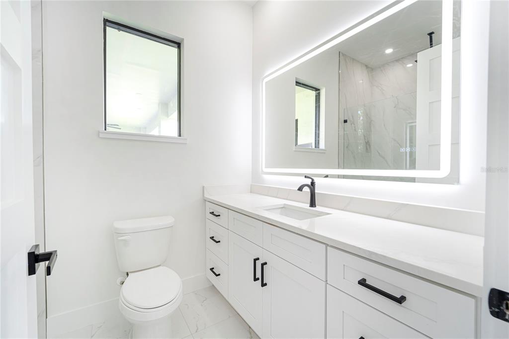 14080 Sydney Road Dover, FL 33527 - Photo 30 of 51 a bathroom with a toilet sink and mirror