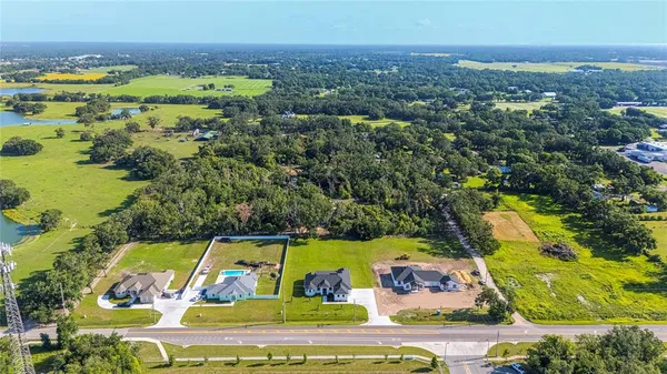 an aerial view of residential houses with outdoor space and river
