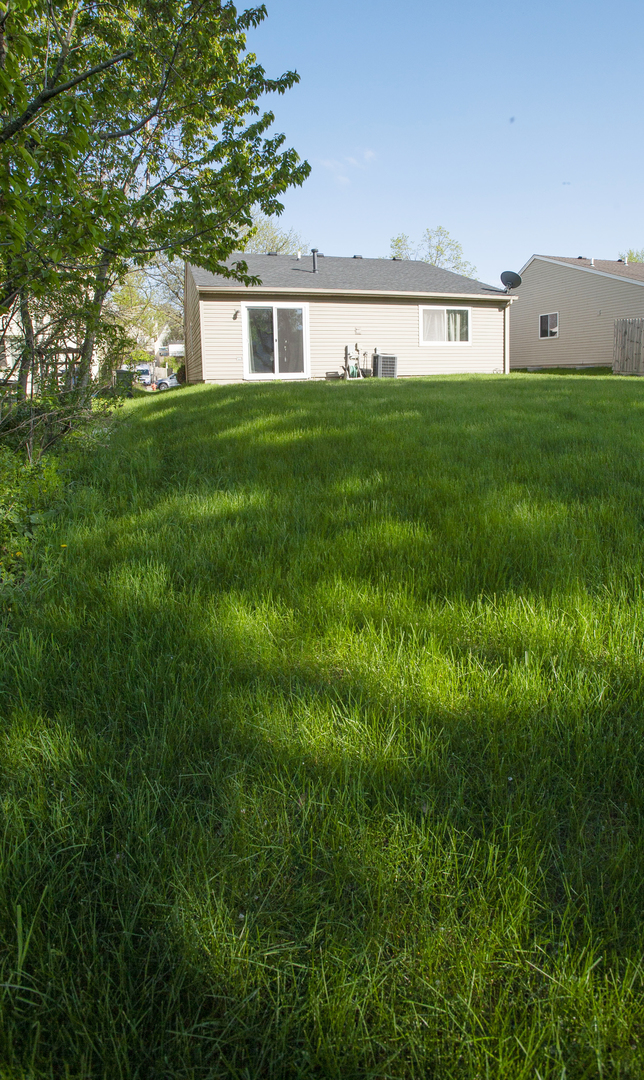 662 Dover Drive Elgin, IL 60120 - Photo 5 of 23 a view of a house with a big yard and large trees