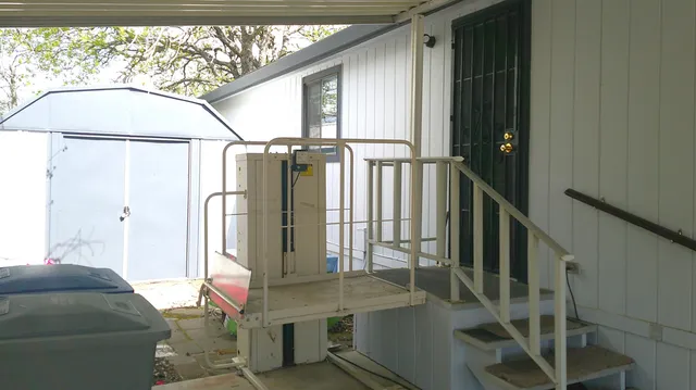 a view of a yard with plants and a large tree