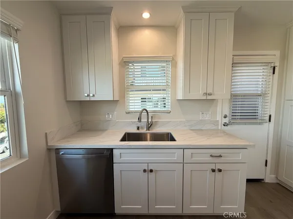 a kitchen with white cabinets and a sink