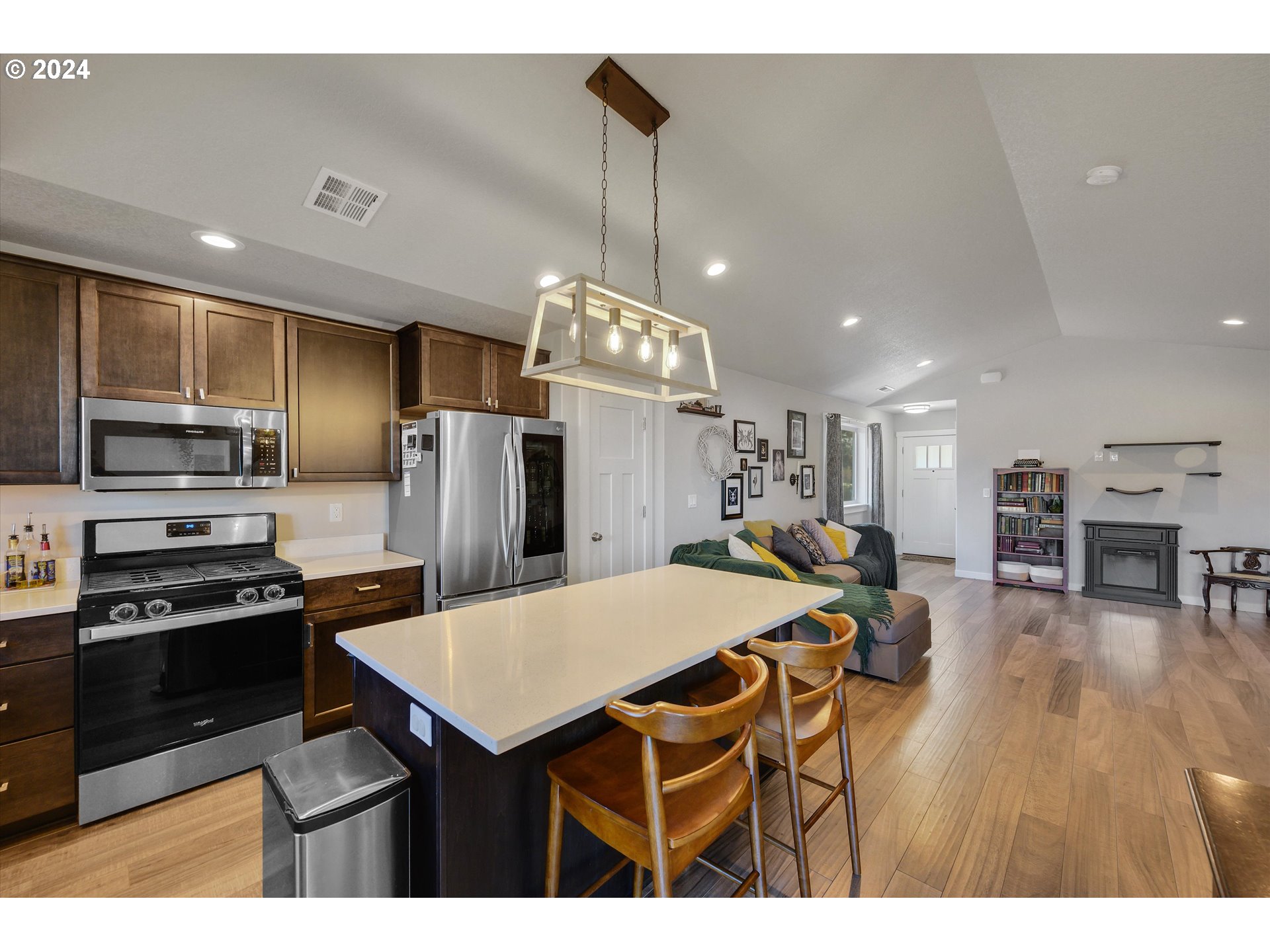 1326 Southwest 9th Street Dallas, OR 97338 - Photo 13 of 32 a kitchen with stainless steel appliances kitchen island granite countertop a dining table chairs refrigerator and sink