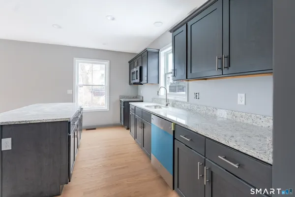 a kitchen with stainless steel appliances granite countertop a sink stove and cabinets