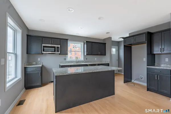 a kitchen with stainless steel appliances granite countertop a refrigerator stove microwave and sink