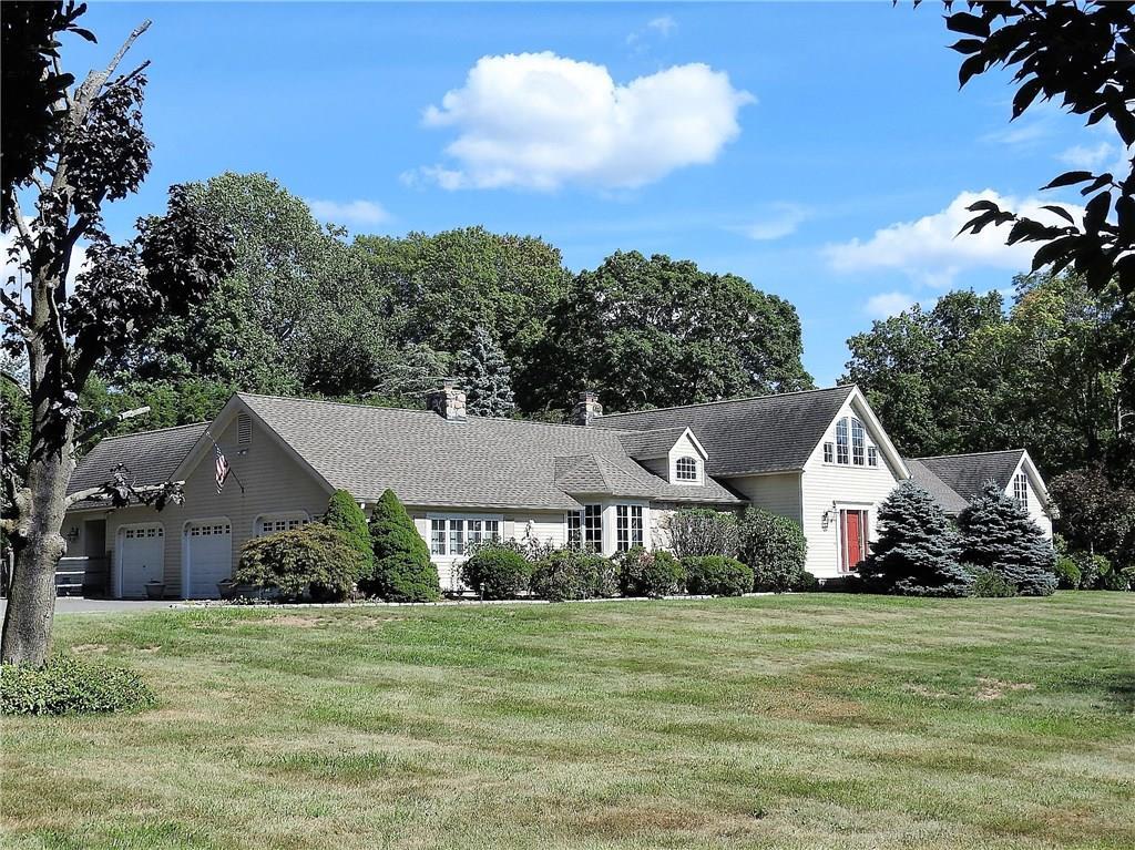 a front view of a house with a yard and trees