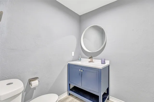 a bathroom with a toilet sink vanity and mirror