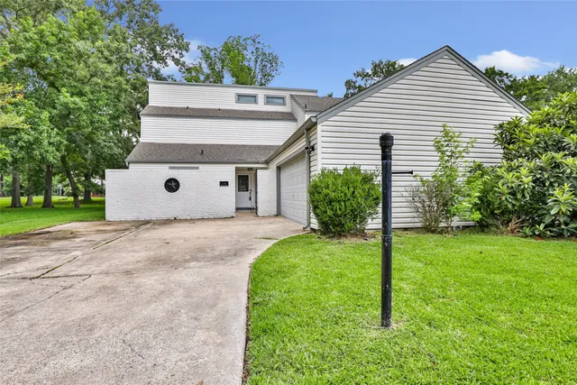a view of a house with backyard and a garden