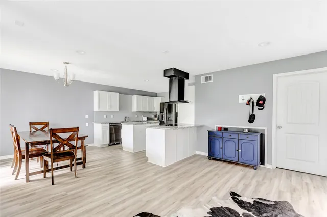 a kitchen with cabinets and wooden floor