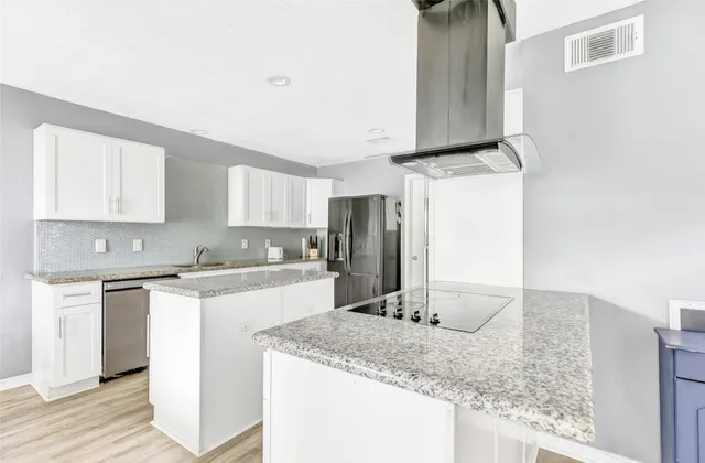 a kitchen with stainless steel appliances granite countertop a sink stove and refrigerator