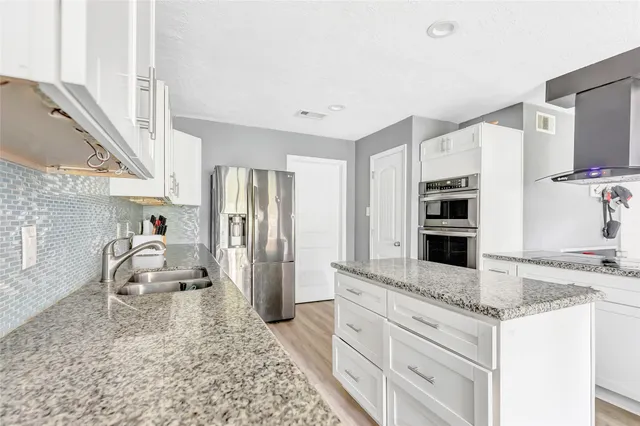 a kitchen with stainless steel appliances granite countertop a sink stove and refrigerator