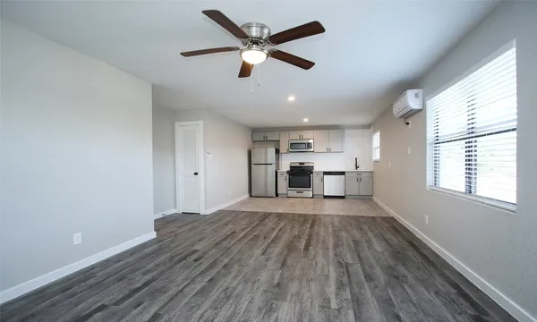a view of empty room with wooden floor and window