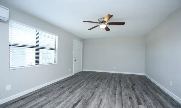 a view of empty room with wooden floor and window
