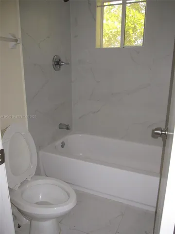 a white bath tub sitting next to a toilet