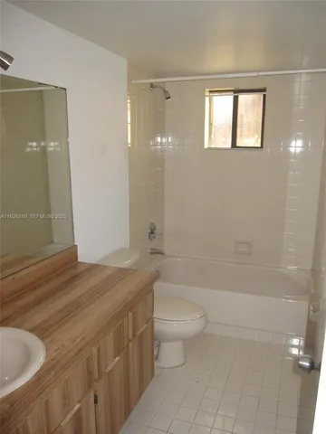a bathroom with a granite countertop sink a toilet and shower