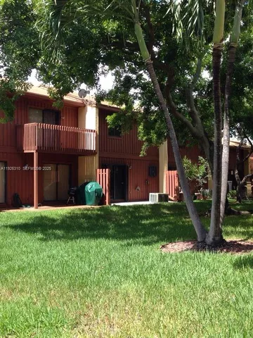 a front view of a house with a yard and trees