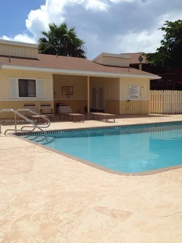 a view of a house with pool and a yard