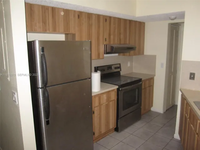 a kitchen with a refrigerator sink and cabinets