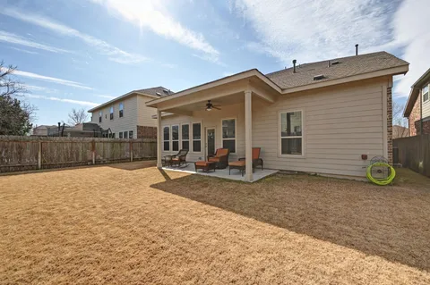 a view of a house with backyard and a tree