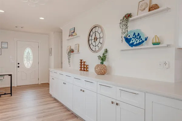 a hallway with painting on the wall and a wooden floor