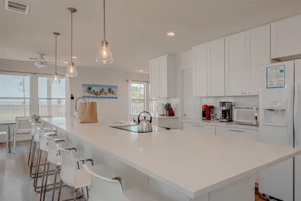 a kitchen with stainless steel appliances a white table chairs and white cabinets