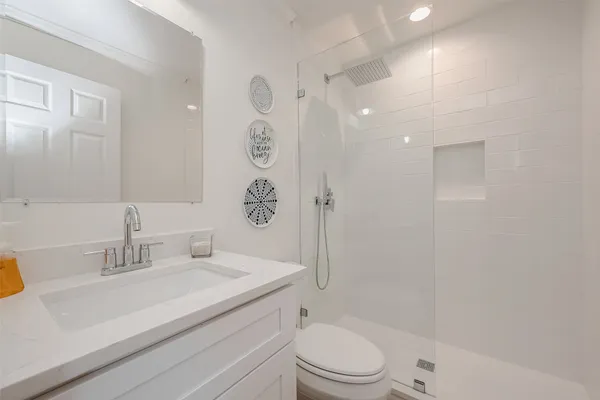 a bathroom with a sink a toilet and shower