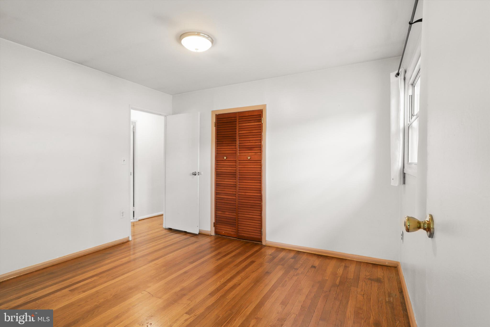10205 Rodgers Road Fairfax, VA 22030 - Photo 12 of 41 an empty room with wooden floor and windows