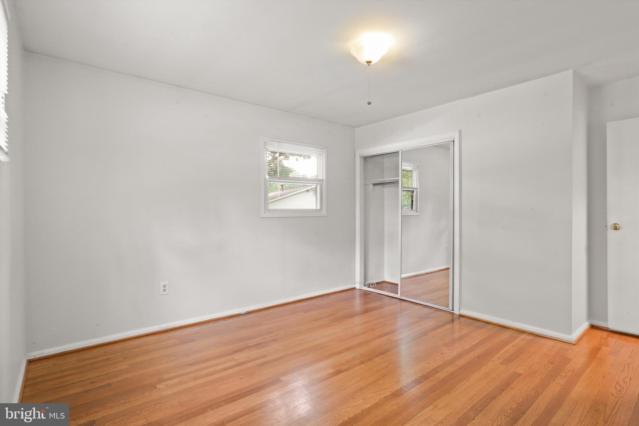 10205 Rodgers Road Fairfax, VA 22030 - Photo 18 of 41 an empty room with wooden floor and windows
