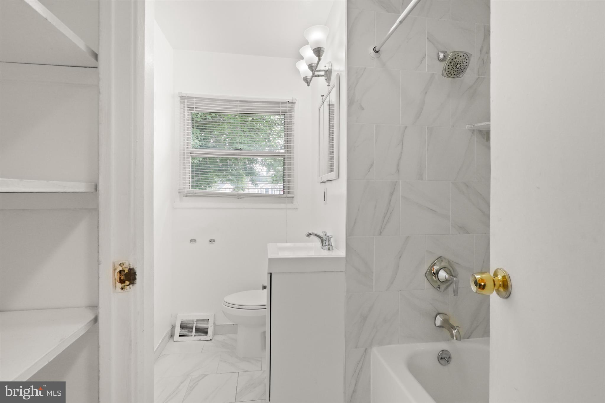 10205 Rodgers Road Fairfax, VA 22030 - Photo 19 of 41 a bathroom with a bathtub a window a shower and vanity