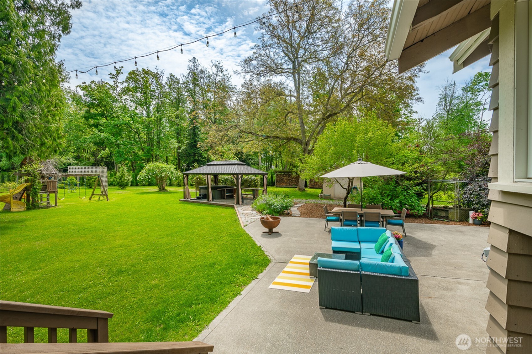 4478 Rural Avenue Bellingham, WA 98226 - Photo 23 of 40 a view of a patio with couches table and chairs under an umbrella