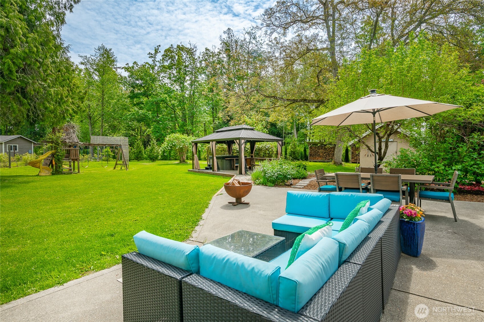 4478 Rural Avenue Bellingham, WA 98226 - Photo 24 of 40 a view of a patio with couches table and chairs under an umbrella