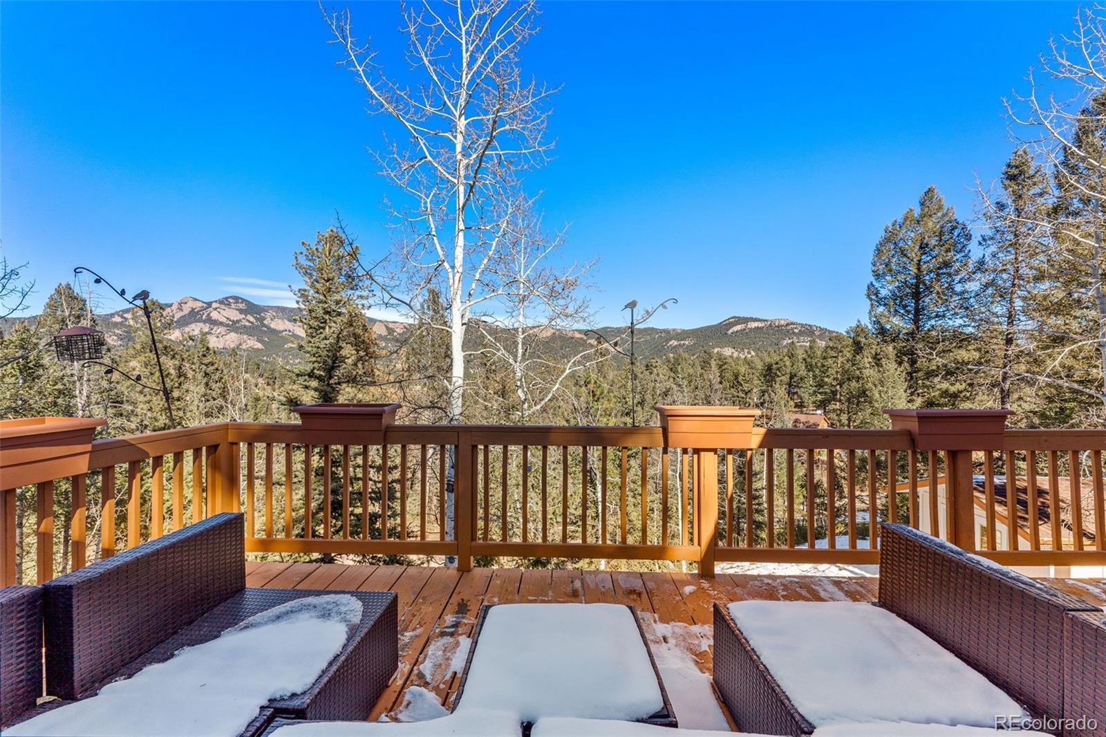 33782 Nova Road Pine, CO 80470 - Photo 28 of 50 a view of a balcony with wooden chairs and floor to ceiling window