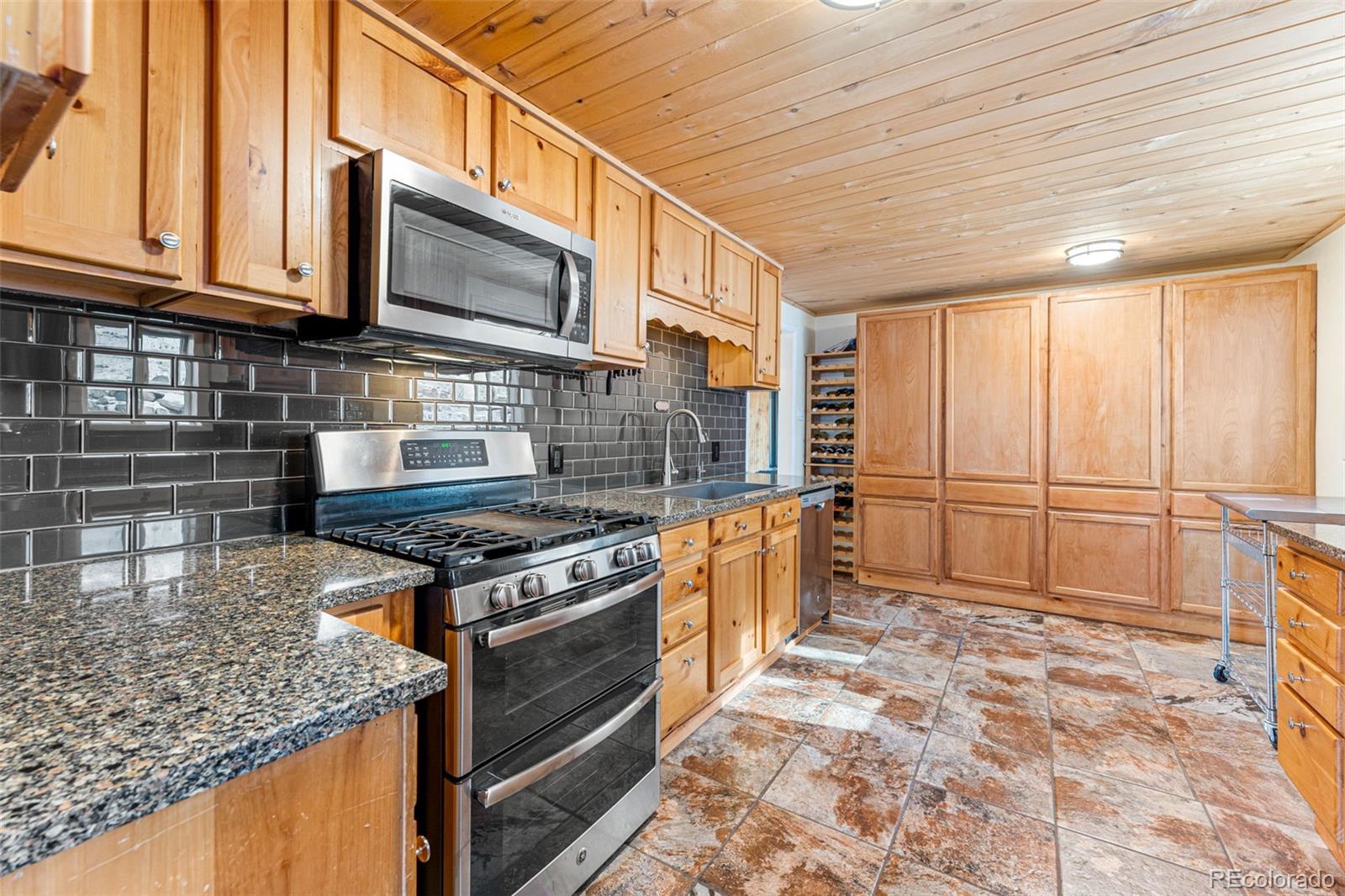 33782 Nova Road Pine, CO 80470 - Photo 7 of 50 a kitchen with stainless steel appliances granite countertop a stove a sink and a microwave