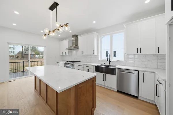 a large kitchen with stainless steel appliances granite countertop a large stove a sink and a microwave