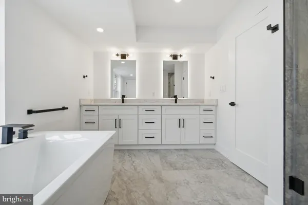 a bathroom with a granite countertop sink a toilet a mirror and shower
