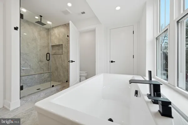 a large white bathroom with a large mirror vanity and a sink