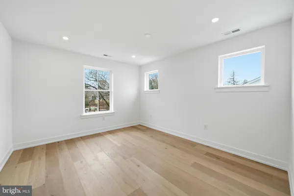 an empty room with wooden floor and stairs