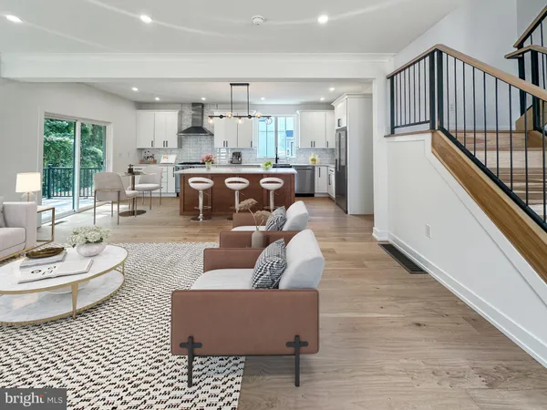 a living room with furniture and view of kitchen