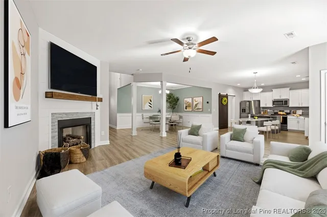 a living room with furniture a fireplace and a flat screen tv