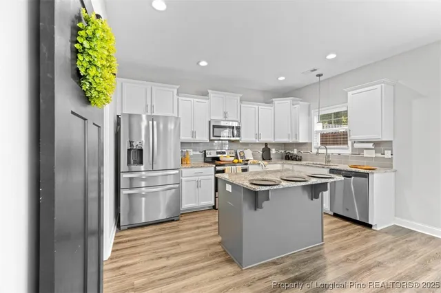 a kitchen with a sink a counter top space stainless steel appliances and cabinets