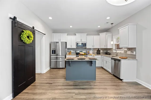 a kitchen with a refrigerator and a stove top oven