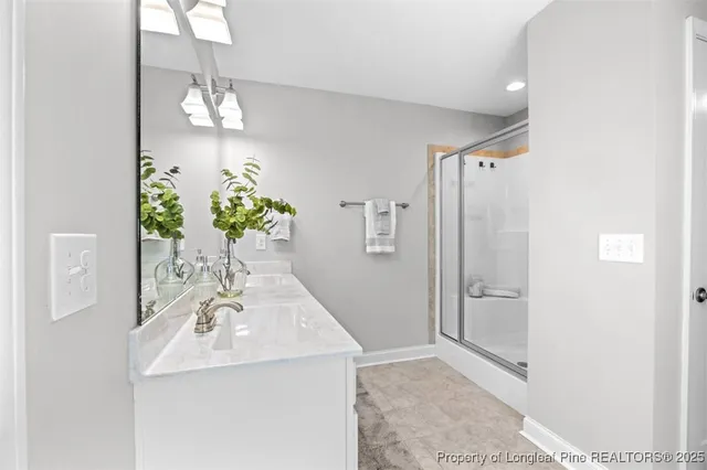 a bathroom with a sink shower and a mirror