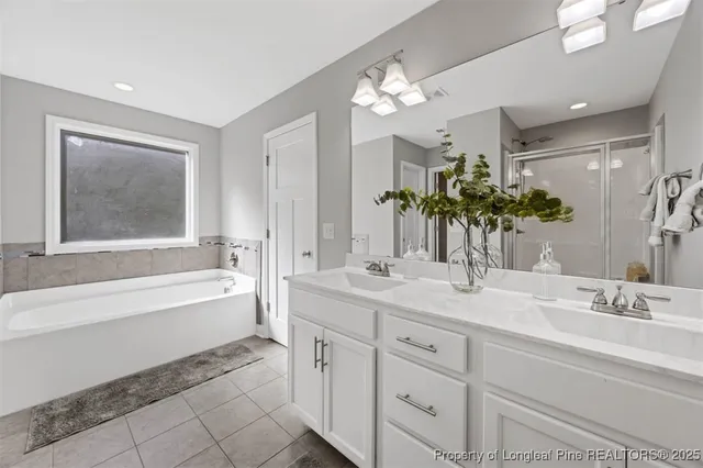 a bathroom with a tub sink and mirror