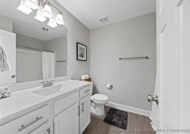 a bathroom with a sink a toilet a light fixture and a mirror