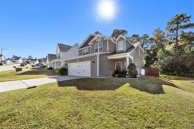 a view of a house with a yard and a pond