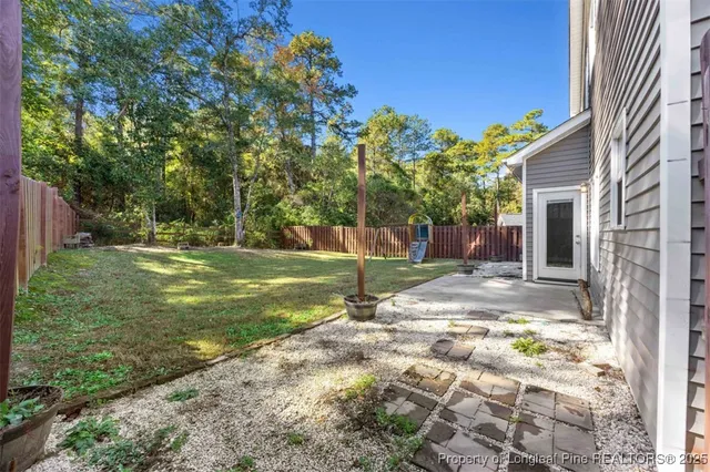 a view of a house with backyard and trees