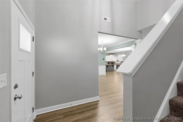 a view of hallway with stairs and wooden floor