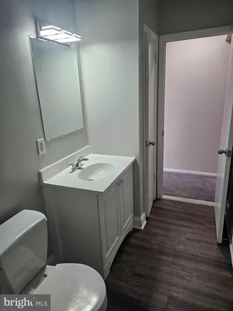 a bathroom with a sink a mirror a toilet and vanity