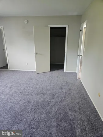 an empty room with closet and a bathroom