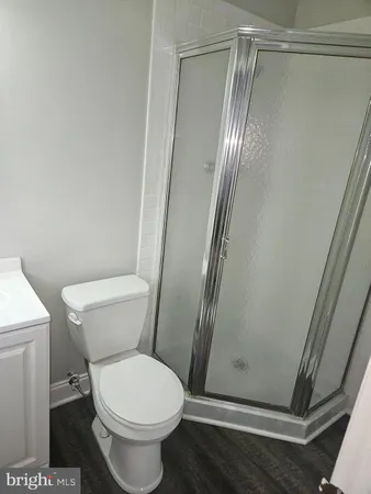 a white toilet sitting next to a shower