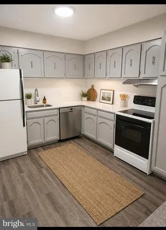 a kitchen with granite countertop cabinets stainless steel appliances and a sink
